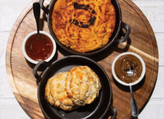 biscuts, gravy, and an array of other dishes over a white brick table