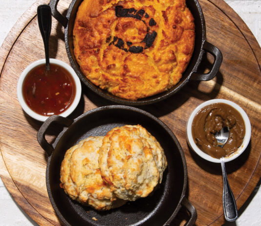 biscuts, gravy, and an array of other dishes over a white brick table