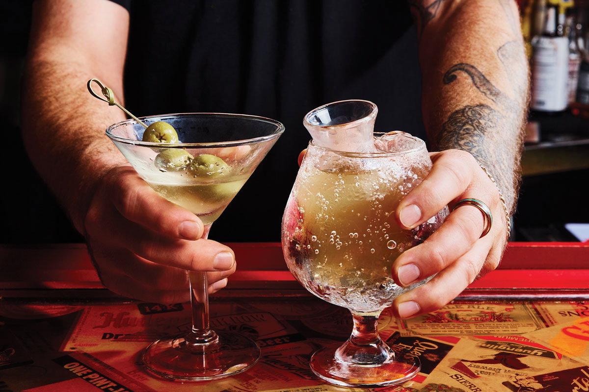 A bartender hands out two cocktails