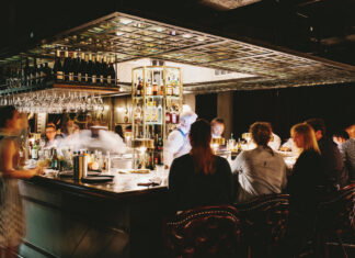 Patrons sit at a square bar