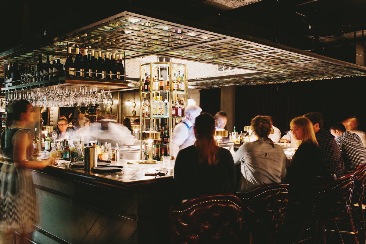 Patrons sit at a square bar