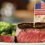 7 Atlanta restaurants where a steak won’t break the bank A medium rare steak with a U.S. flag toothpick in it from Ted’s Montana Grill