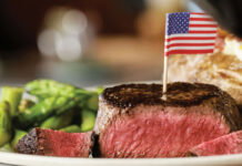 A medium rare steak with a U.S. flag toothpick in it from Ted’s Montana Grill